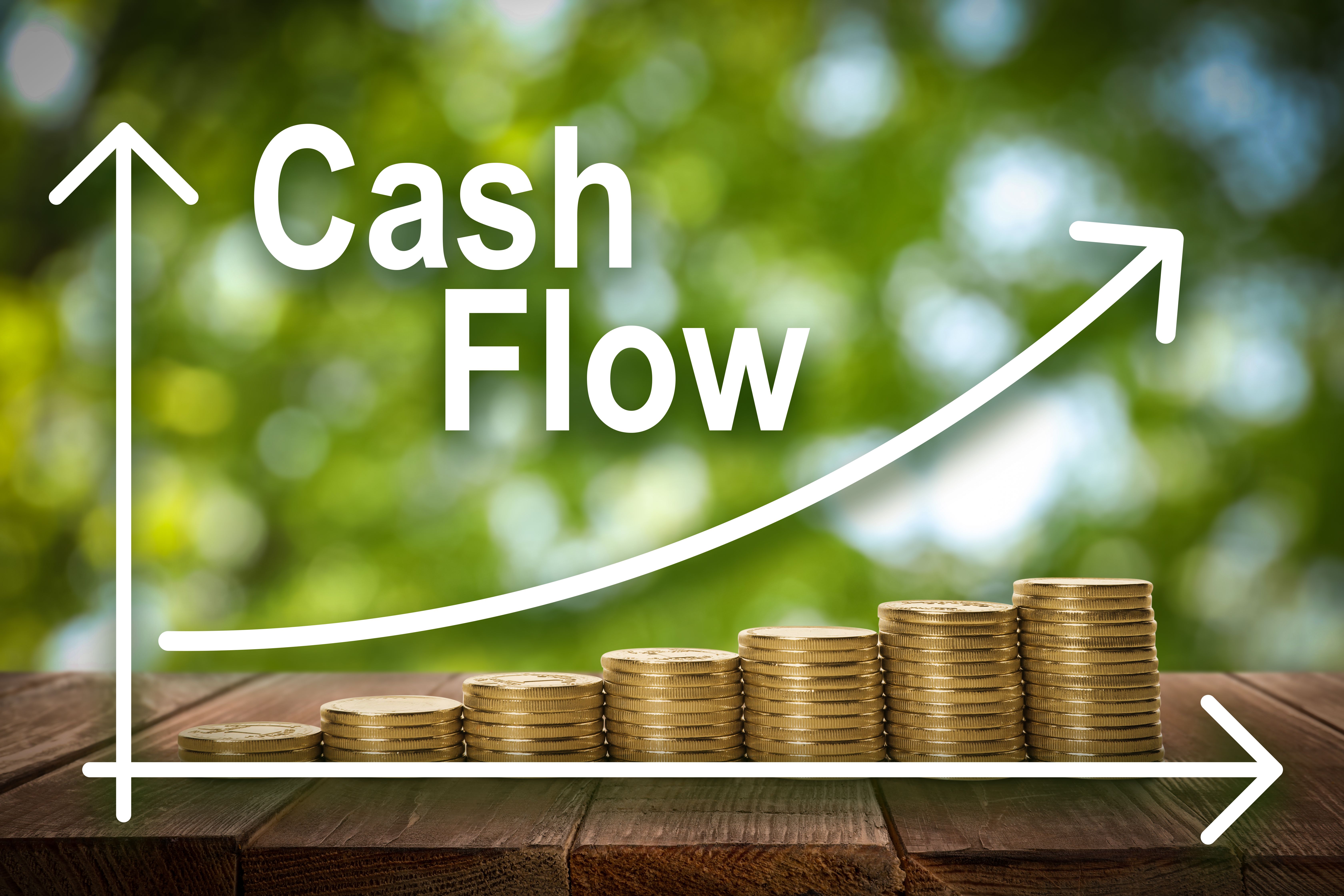 cash-flow-concept-illustration-increase-graph-stacked-coins-wooden-table-against-blurred-green-background.jpg