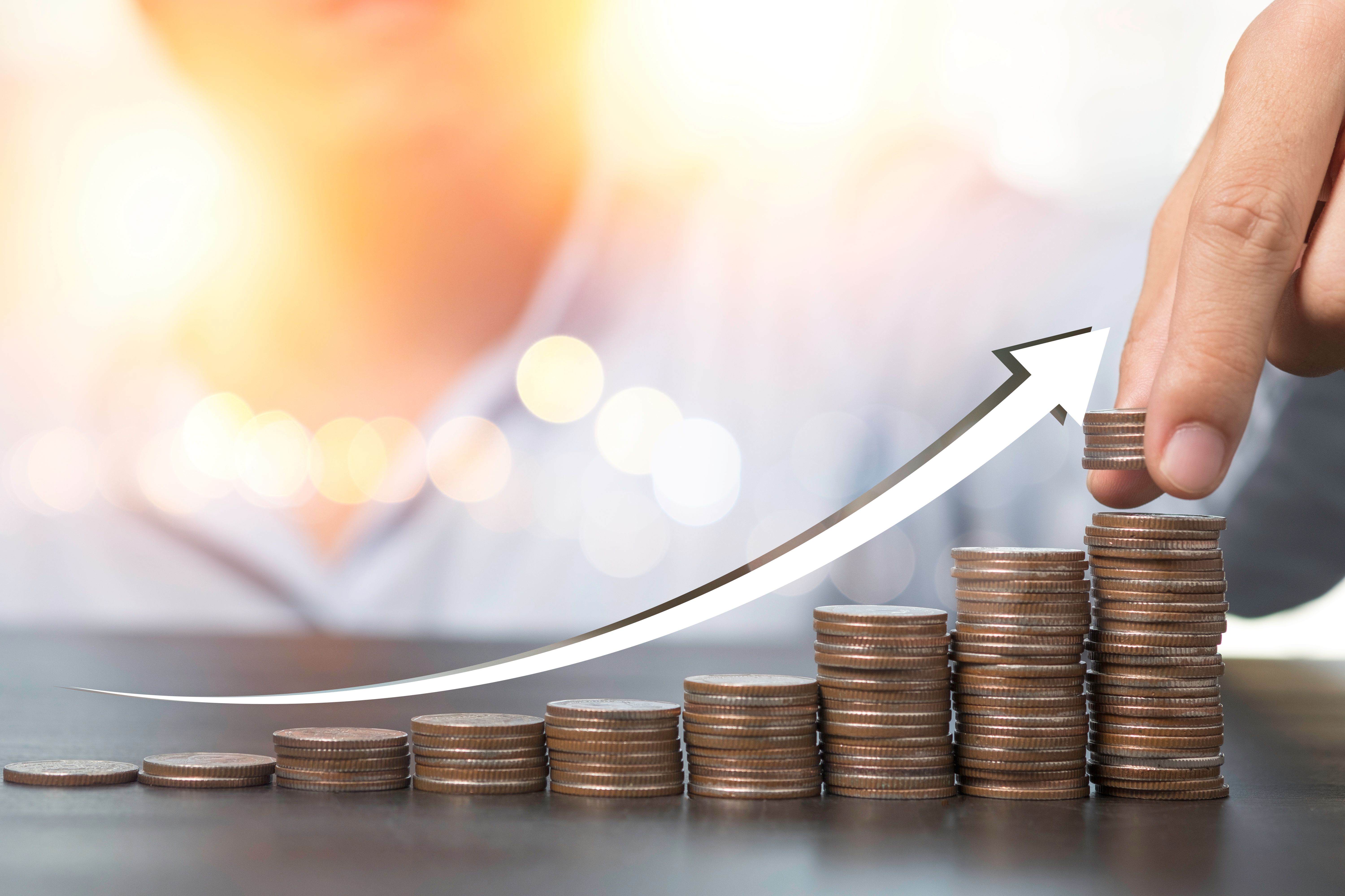 hand-putting-coins-stacking-with-rising-arrow-dividend-banking-deposit-stock-investment-concept.jpg