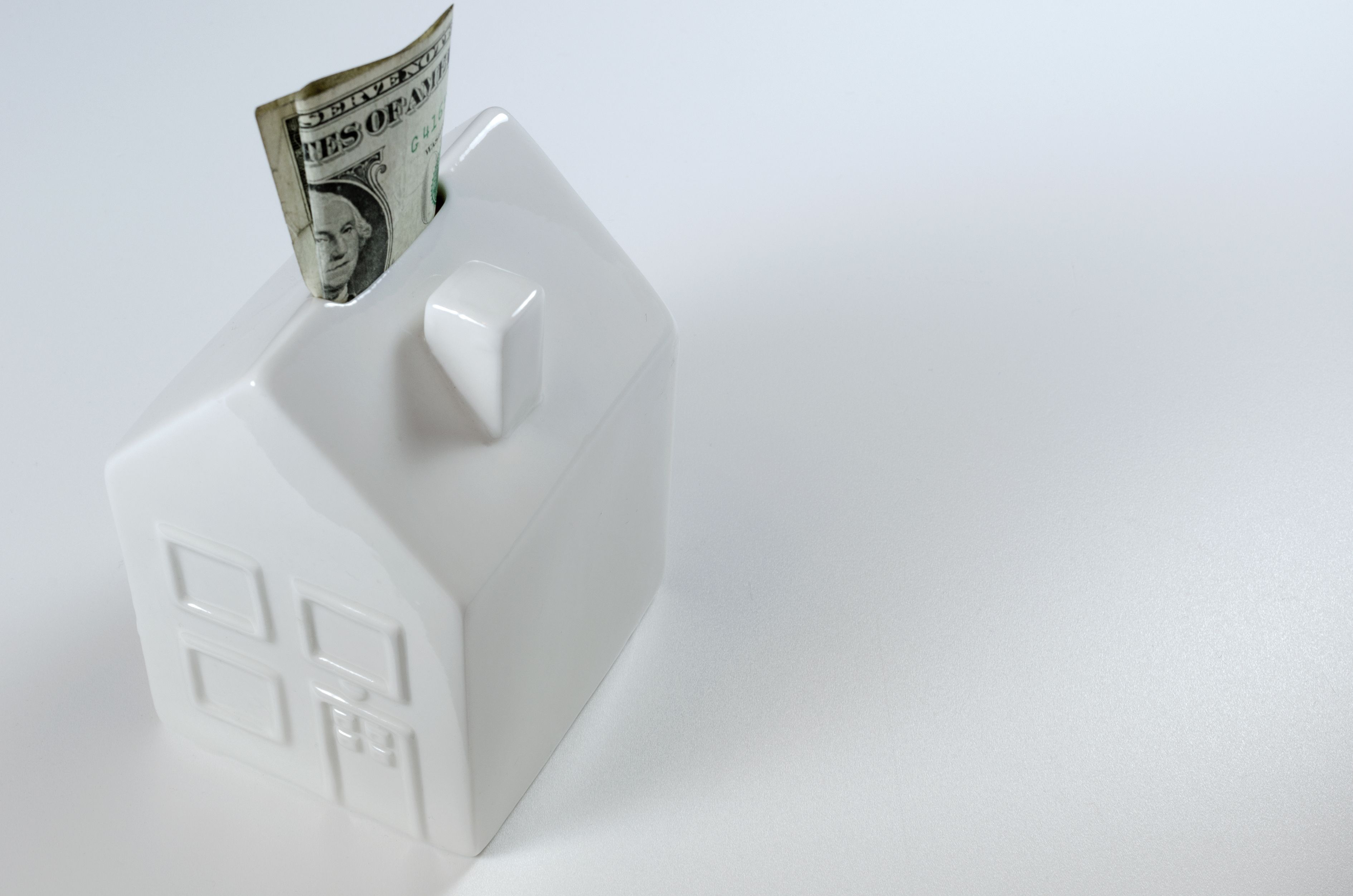 high-angle-view-model-home-with-paper-currency-white-background.jpg