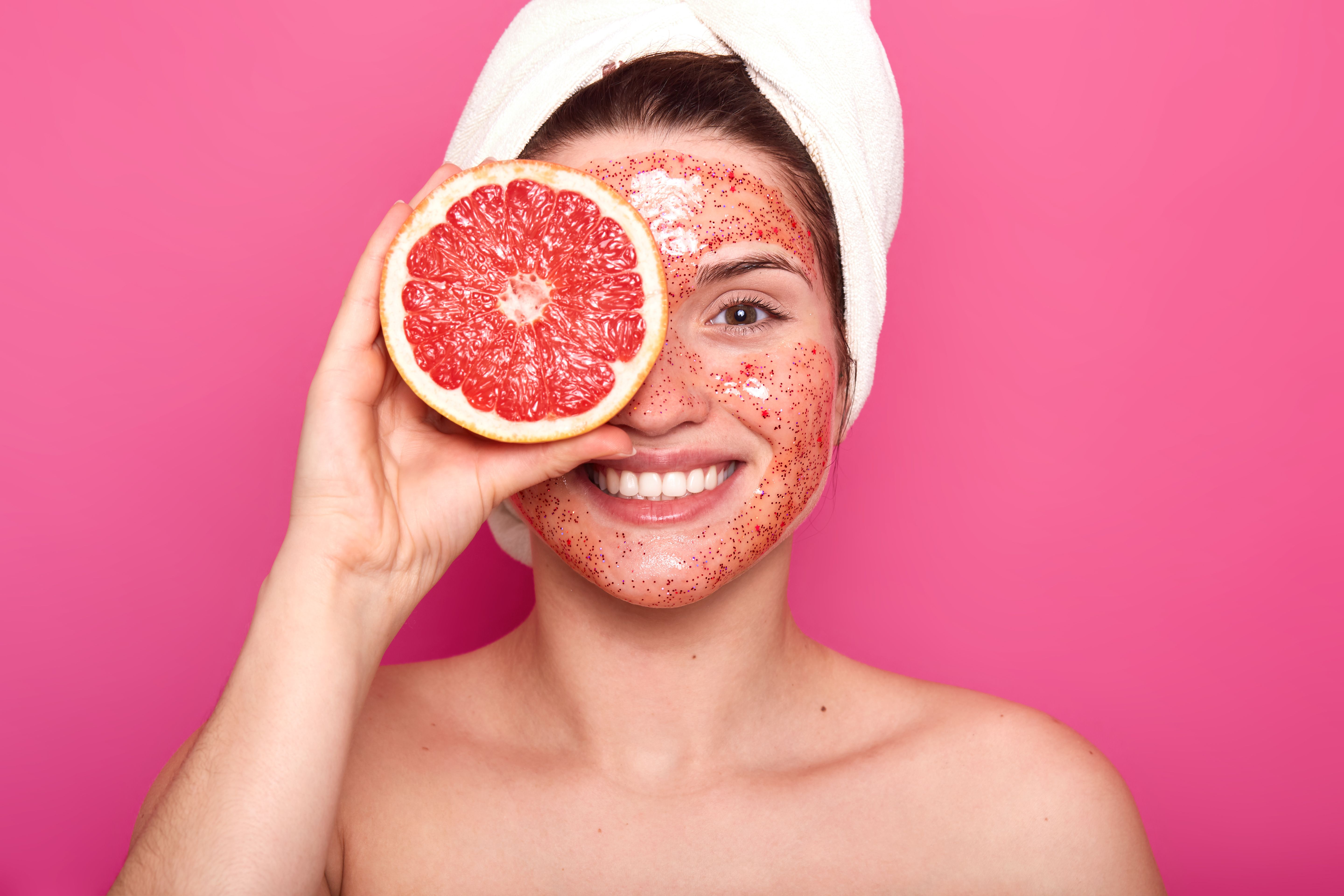 emotional-charismatic-young-woman-with-beautiful-smile-her-face-spends-time-doing-beauty-procedures-makes-her-skin-fresh-clean-holds-half-grapefruit-with-white-towel-her-head.jpg